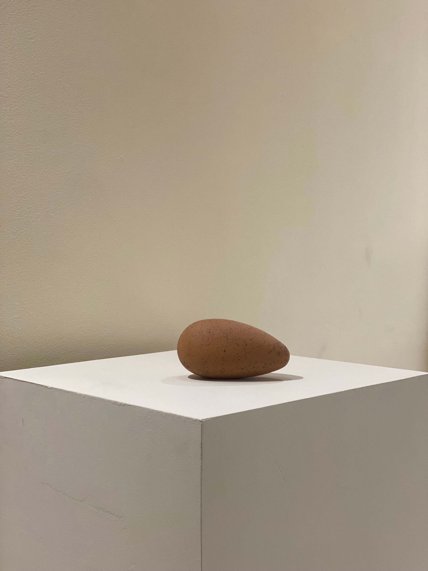 Handcrafted red brown abstract clay sculpture on white pedestal, unique aesthetic, created using slab technique, dimensions 7x8x14 inches